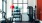 The Charley Apartments | A modern gym at The Charley Apartments in Allston MA features cardio machines, a rack of colorful exercise balls and dumbbells, and strength training equipment, all set by large windows with natural light. | Apartments with Fitnes