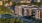The Charley Apartments | A cityscape shows The Charley Apartments in Allston MA, with modern buildings, a tree-lined street filled with cars, and older architecture in the background, all bathed in late afternoon sunlight. | Apartments with Air Conditioni