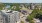 The Charley Apartments | Aerial view of The Charley Apartments in Allston MA, surrounded by trees, with a river on the left, nearby roads, and urban buildings in the background under a clear blue sky. | Boston Waterfront Apartments 